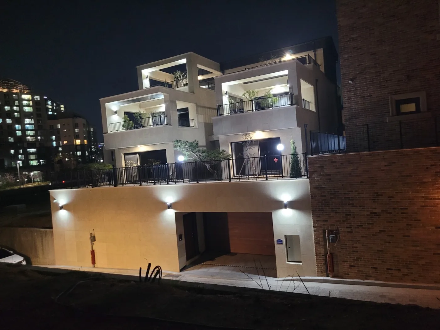 저녁에 조명이 켜진 스톤 클래딩 주택